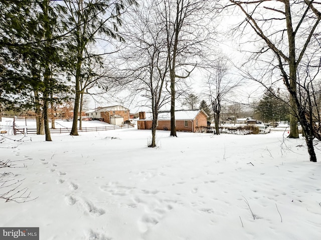 snowy yard with a garage