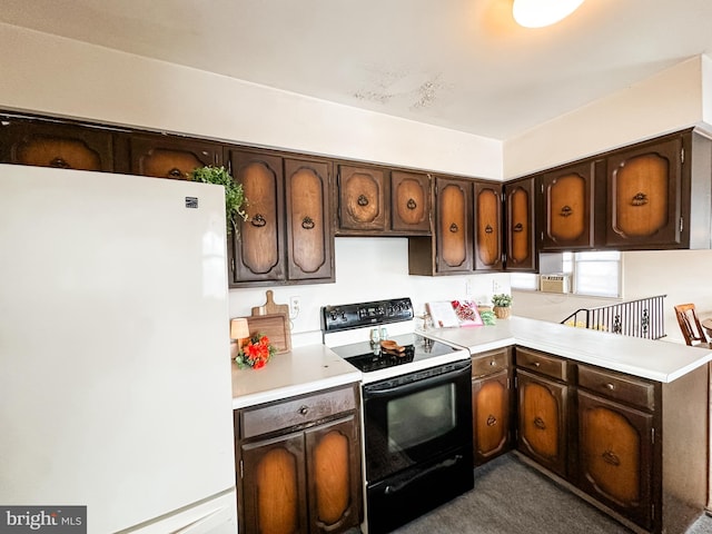 kitchen featuring dark brown cabinetry, electric range, freestanding refrigerator, a peninsula, and light countertops