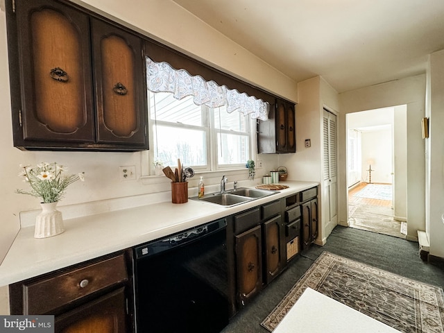 kitchen featuring dark brown cabinetry, baseboards, dishwasher, light countertops, and a sink