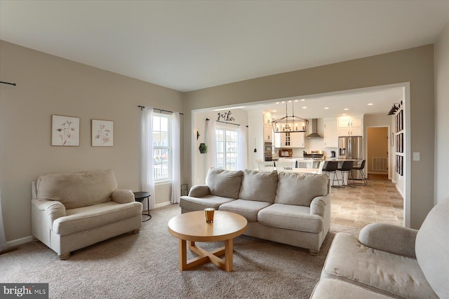 carpeted living room with a chandelier