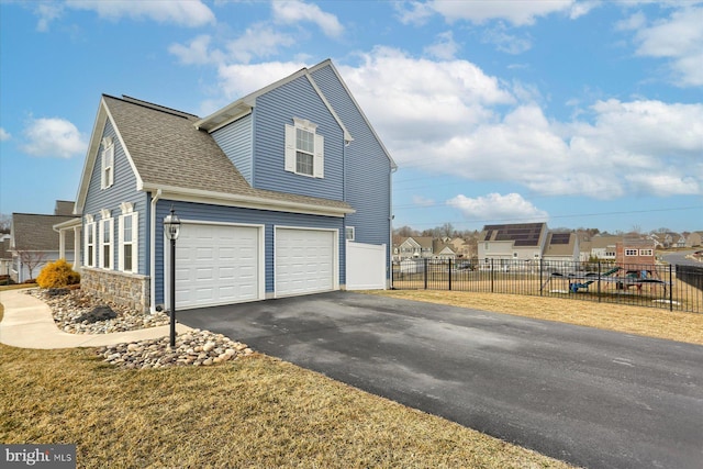 view of home's exterior with a garage and a lawn