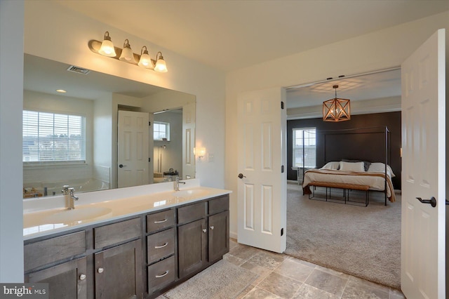 bathroom with vanity, a wealth of natural light, and a tub