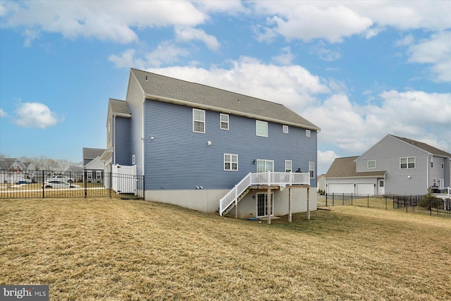 back of house featuring a wooden deck and a lawn