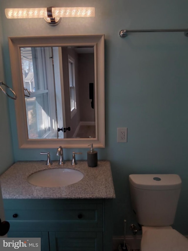 half bathroom with vanity and toilet