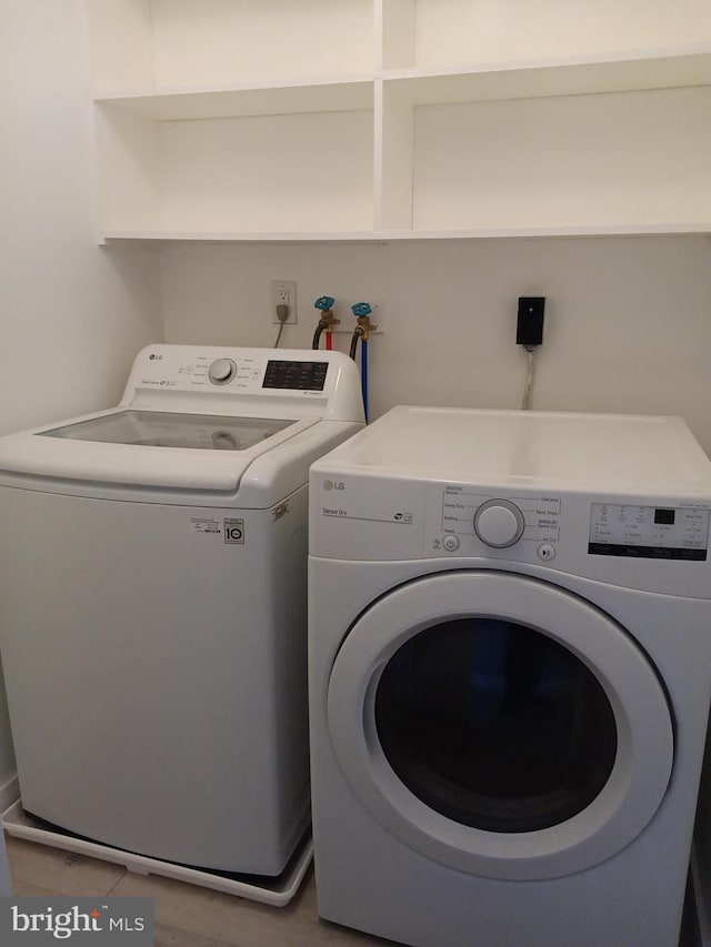 clothes washing area with laundry area and washer and clothes dryer