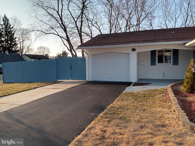 view of front facade featuring a garage, driveway, and fence