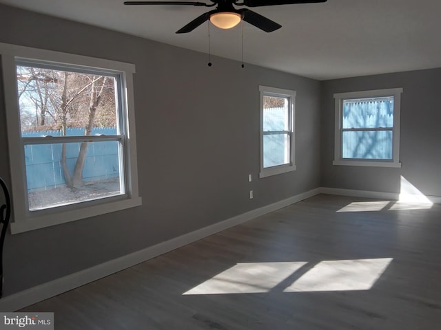 unfurnished room featuring ceiling fan, wood finished floors, and baseboards