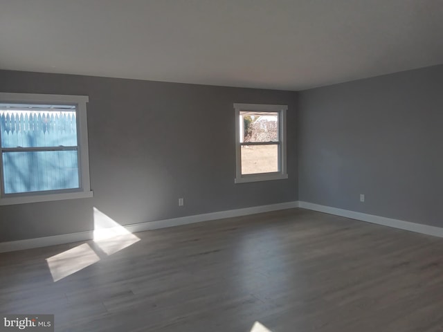 unfurnished room with baseboards and wood finished floors