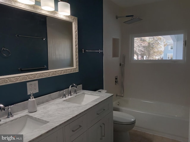 full bath with toilet, double vanity, washtub / shower combination, and a sink