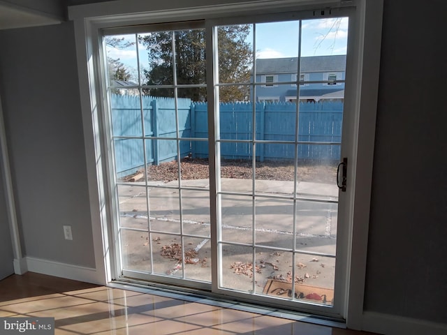 doorway to outside featuring baseboards