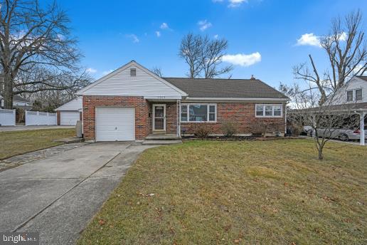 view of front of home with a garage and a front lawn