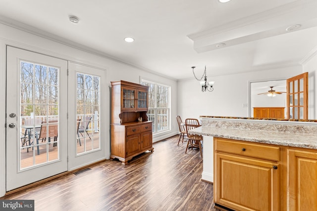 kitchen with dark wood-style floors, visible vents, crown molding, decorative light fixtures, and a notable chandelier