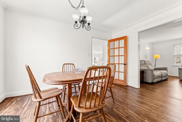 dining space with ornamental molding, baseboards, an inviting chandelier, and wood finished floors