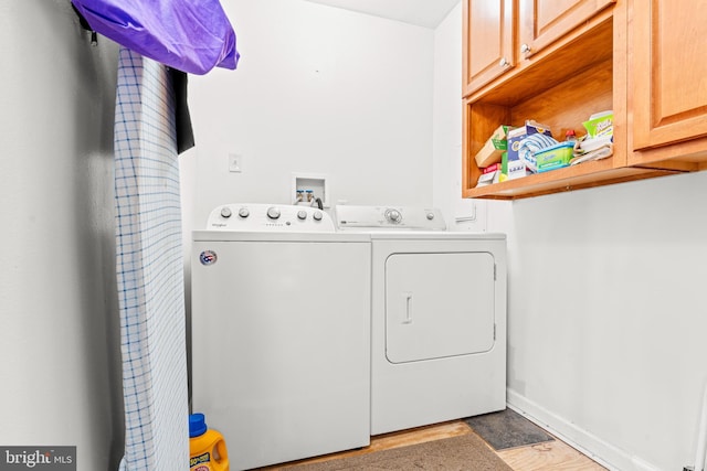 laundry room with cabinet space, baseboards, and separate washer and dryer