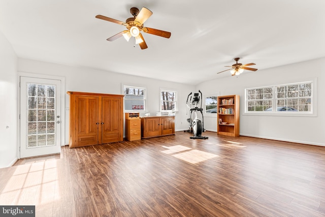 unfurnished living room featuring baseboards, wood finished floors, and a ceiling fan