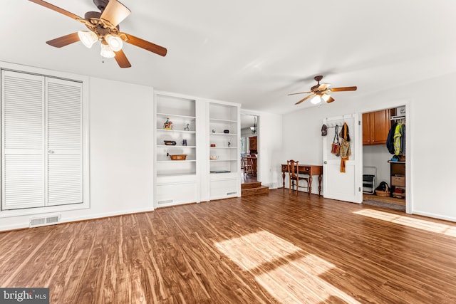 interior space featuring visible vents, baseboards, a ceiling fan, and wood finished floors