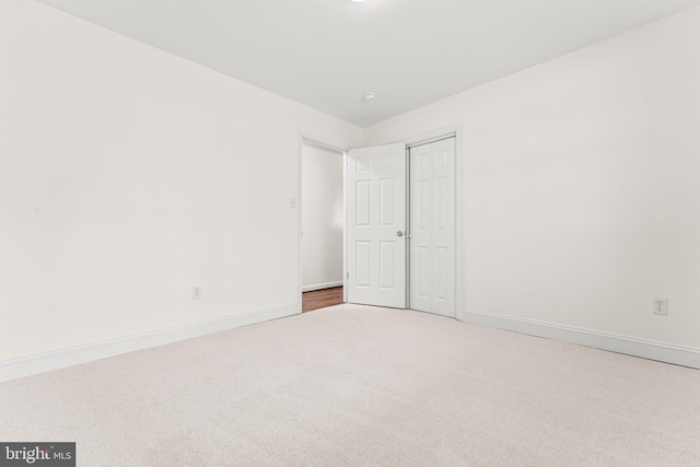 unfurnished bedroom featuring carpet flooring, baseboards, and a closet