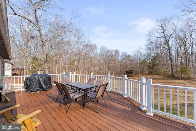 wooden terrace featuring area for grilling and outdoor dining area