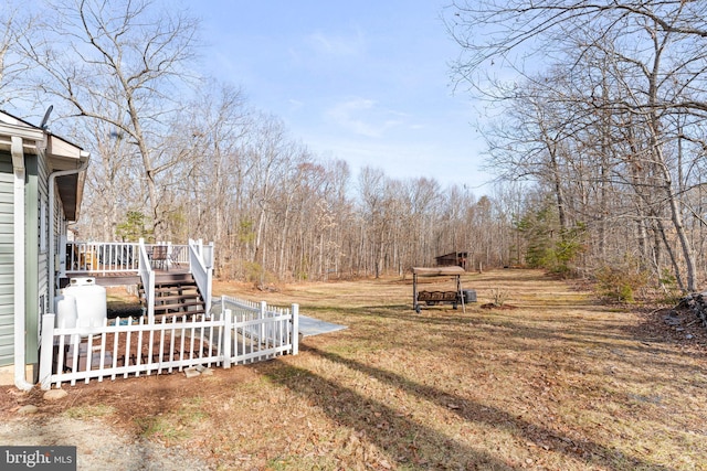 view of yard featuring stairs, a deck, and fence