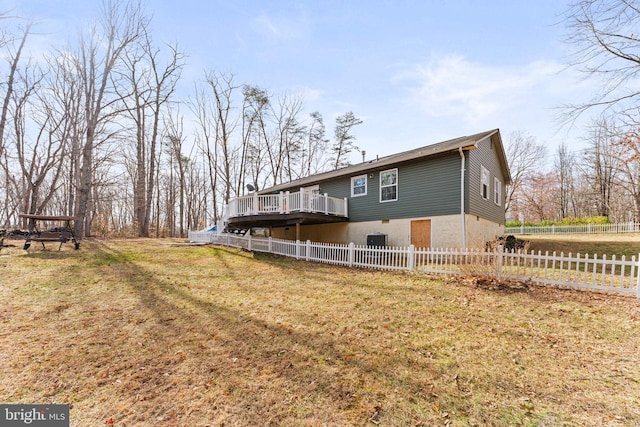 view of side of property featuring fence, a lawn, central AC, and a wooden deck