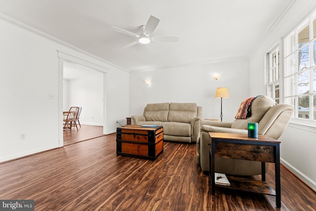 living room featuring dark wood finished floors, a ceiling fan, baseboards, and ornamental molding