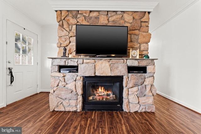 interior details featuring a stone fireplace, wood finished floors, baseboards, and ornamental molding