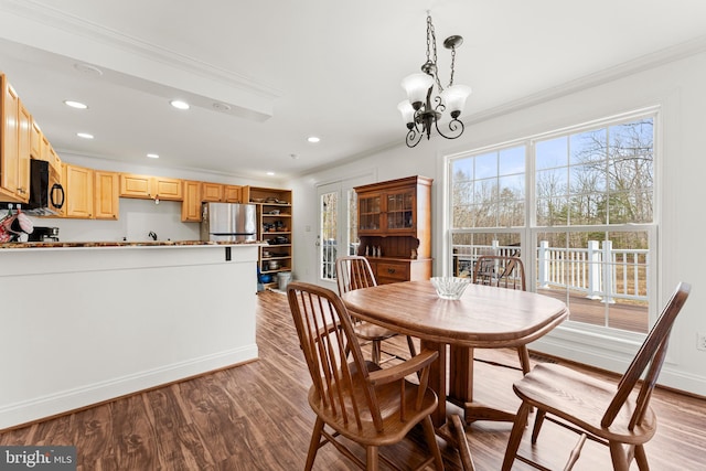 dining space featuring recessed lighting, wood finished floors, an inviting chandelier, and ornamental molding