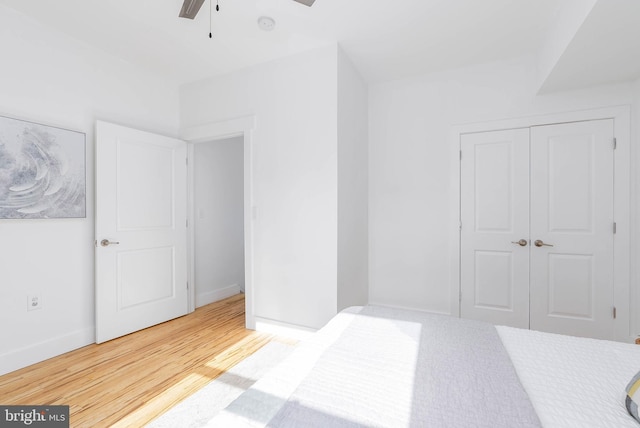 bedroom featuring hardwood / wood-style floors, ceiling fan, and a closet