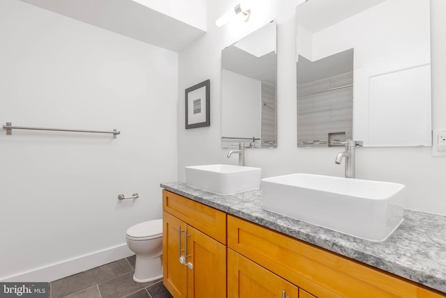 bathroom with tile patterned flooring, vanity, and toilet