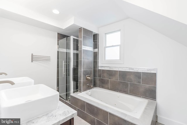 bathroom featuring vanity, shower with separate bathtub, and vaulted ceiling