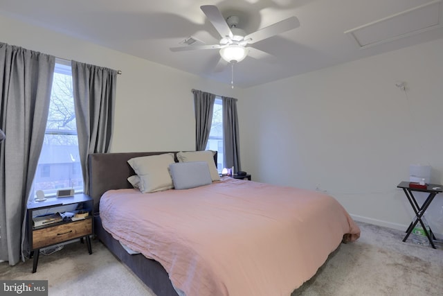 carpeted bedroom featuring ceiling fan and multiple windows