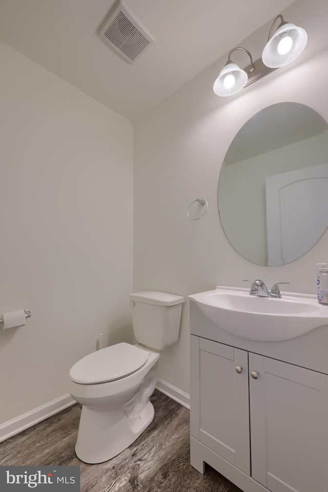 bathroom with vanity, wood-type flooring, and toilet