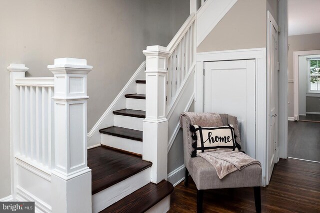 staircase featuring baseboards and wood finished floors