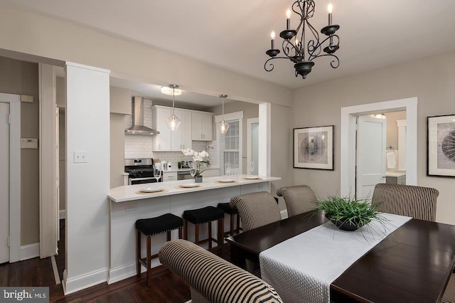 dining area with dark wood-style floors, baseboards, and a chandelier