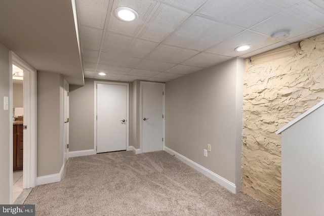 finished below grade area featuring light carpet, recessed lighting, and baseboards