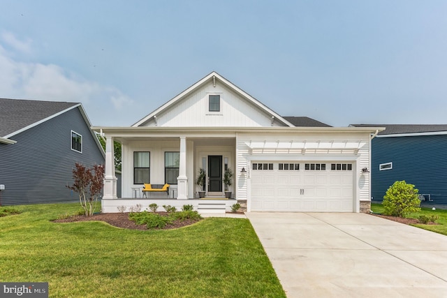 view of front of property featuring a garage, covered porch, and a front lawn