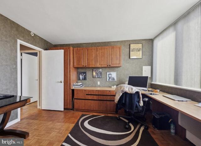 office area with built in desk and light parquet floors