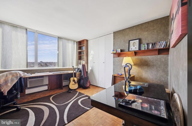 office area with parquet floors and a baseboard heating unit