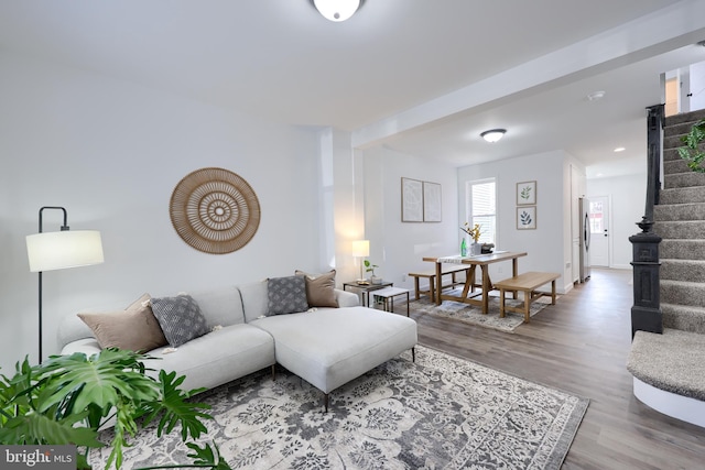 living area with stairway and wood finished floors