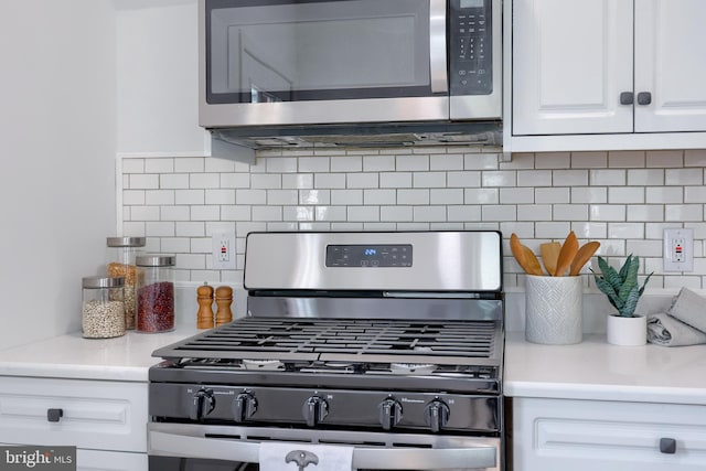 kitchen with tasteful backsplash, light countertops, appliances with stainless steel finishes, and white cabinets