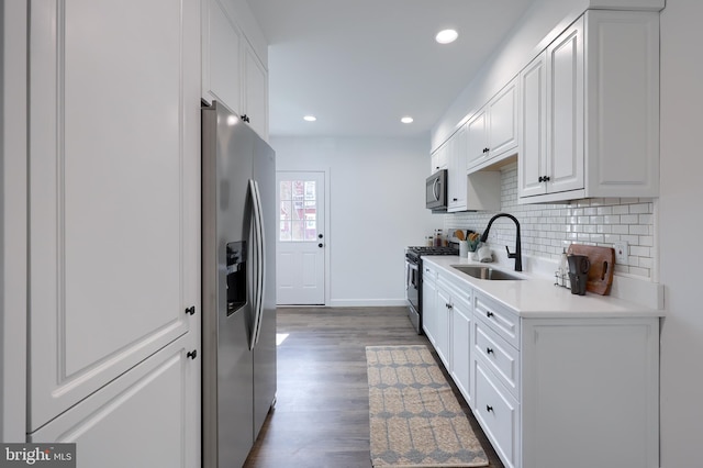 kitchen with a sink, white cabinets, light countertops, appliances with stainless steel finishes, and tasteful backsplash