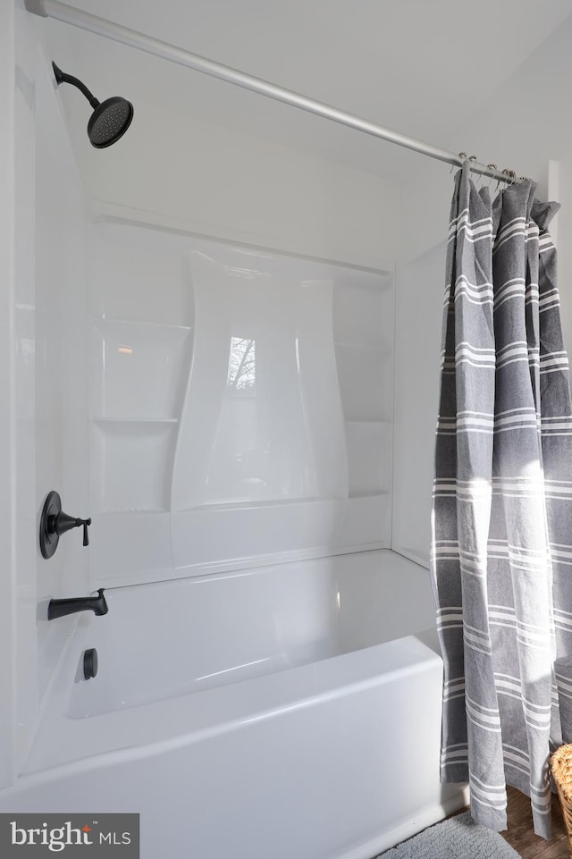 bathroom featuring shower / bath combo and wood finished floors