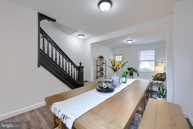 dining space featuring stairway, wood finished floors, and baseboards