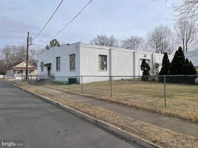 view of side of home featuring cooling unit and a lawn