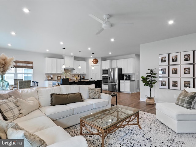 living room with ceiling fan and light hardwood / wood-style floors