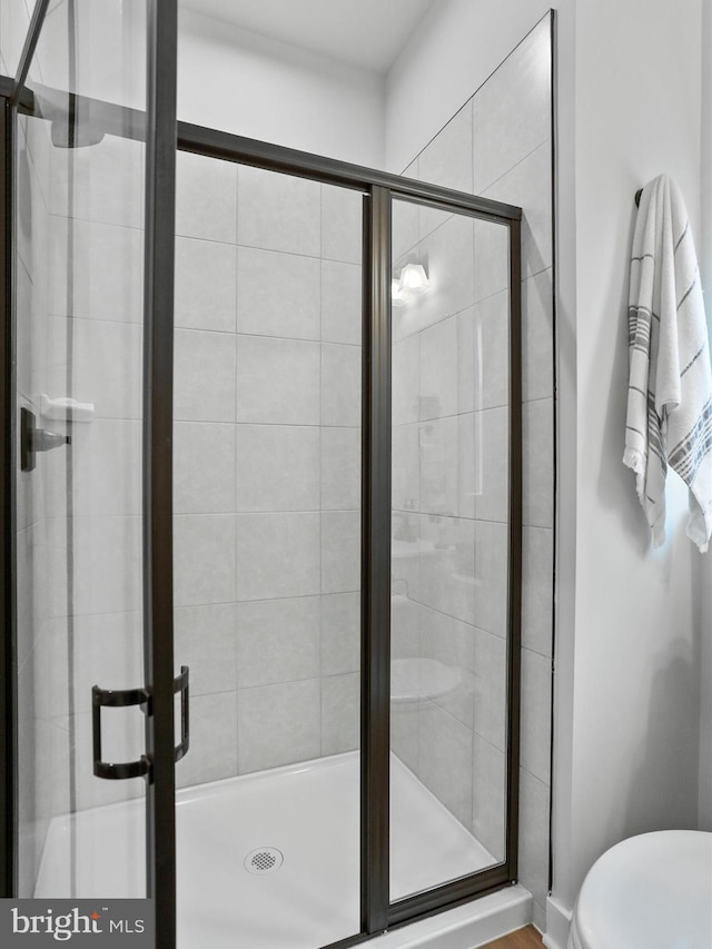 bathroom with an enclosed shower and toilet