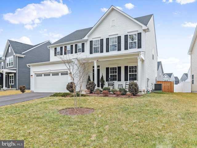 view of front of house with a garage, central AC, a front yard, and covered porch