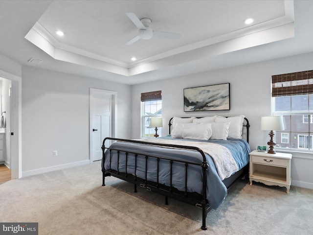 bedroom featuring ceiling fan, a tray ceiling, and carpet