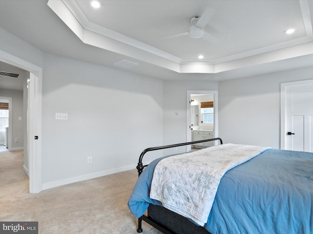 bedroom featuring ornamental molding, light colored carpet, ceiling fan, and a tray ceiling