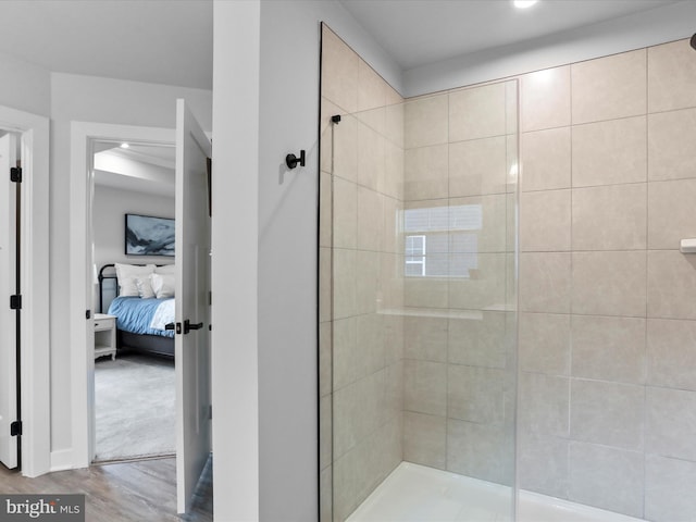 bathroom with hardwood / wood-style flooring and tiled shower